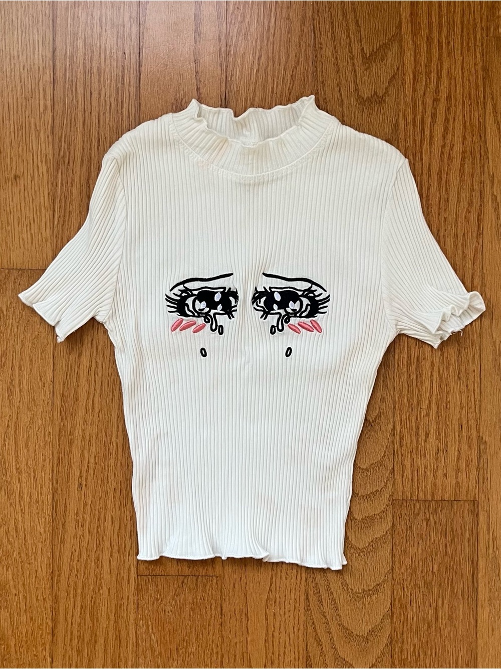 White ribbed crop top with cartoon eyes graphic